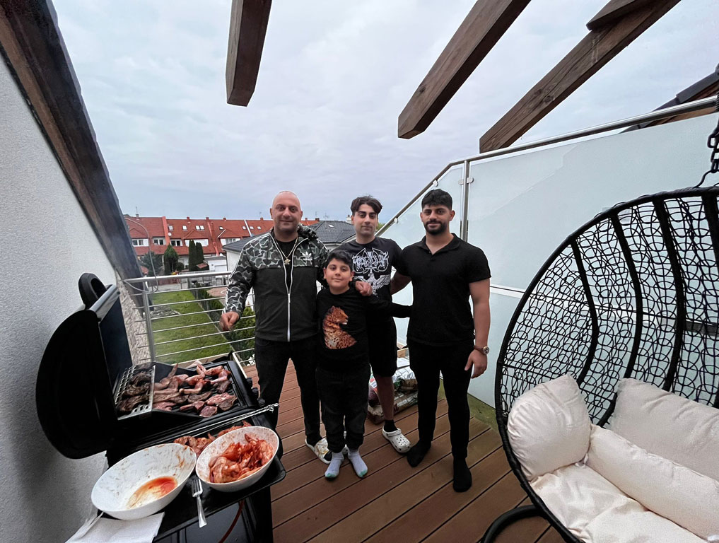 Aile üyeleri barbekü sırasında poz veriyor, baba henüz görselde yok