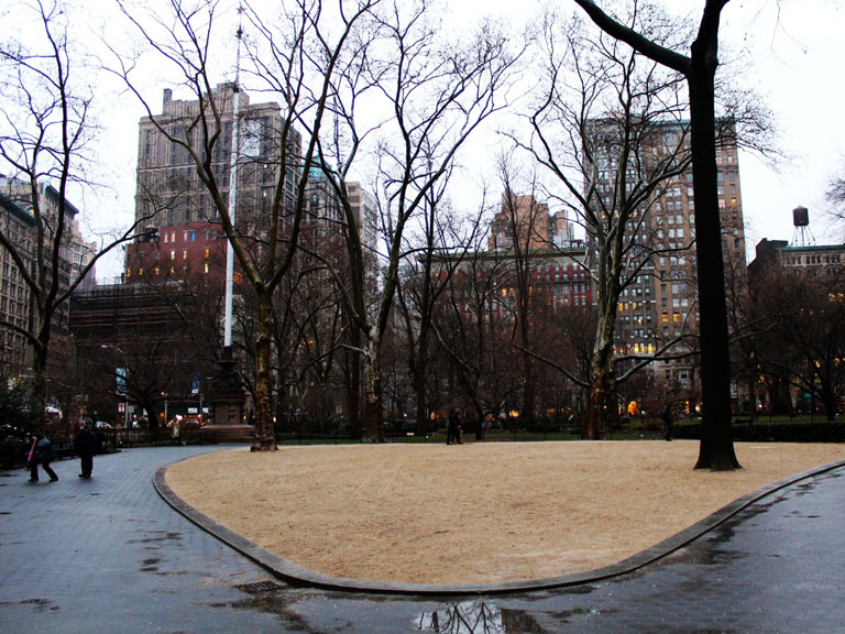Boş arka planla çekilmiş sıradan bir iç mekânda duran kişi